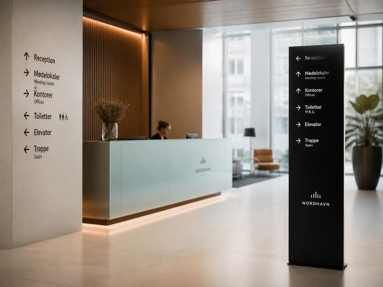Moderne indendørs wayfinding i kontorlobby med pylon og receptionskæde